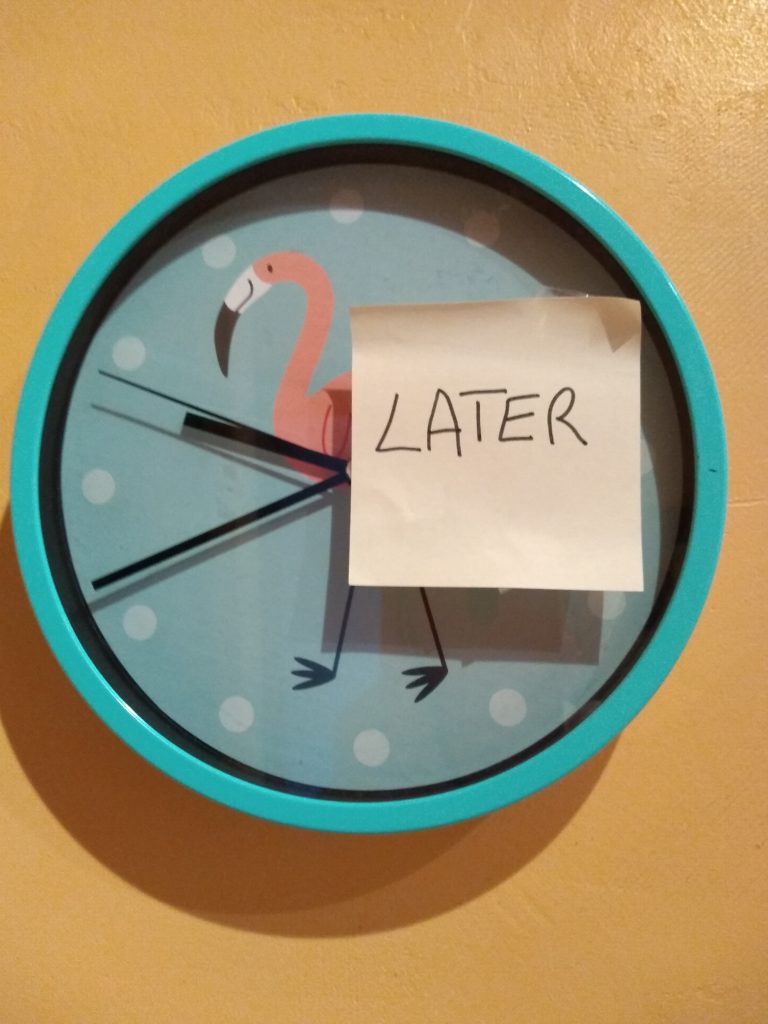 Horloge avec un post-it sur lequel est écrit "Later"