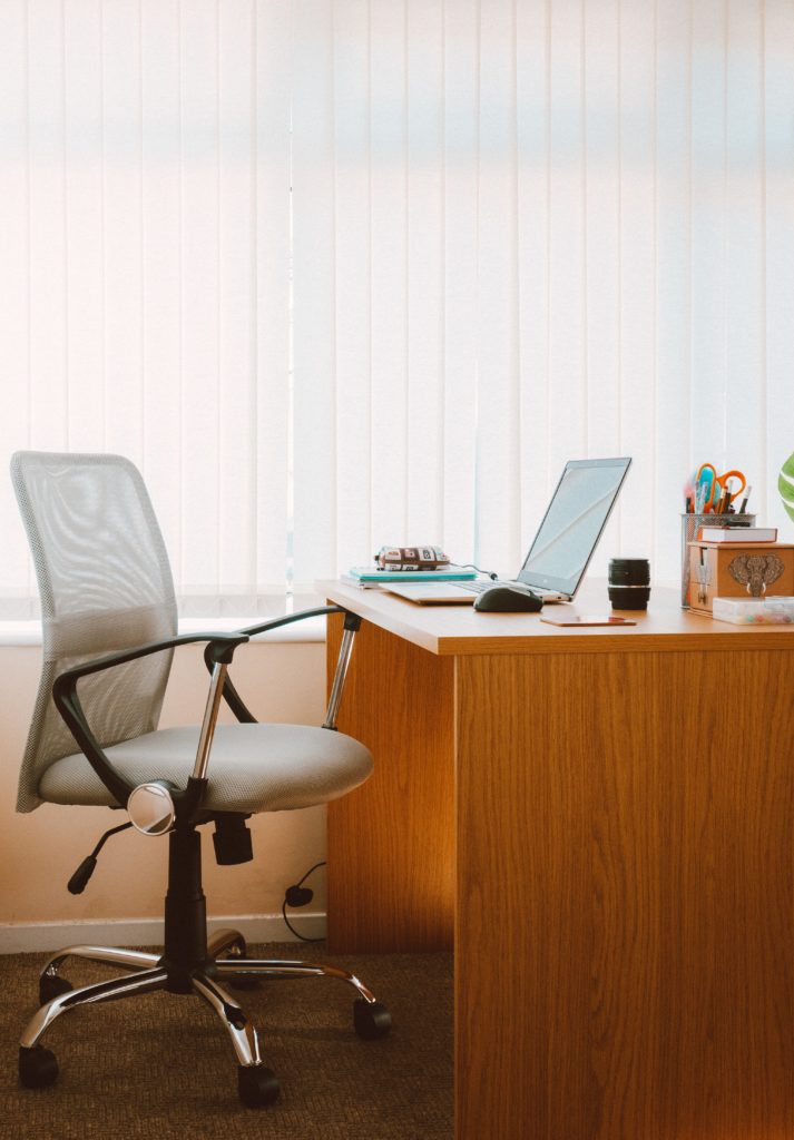Bureau en bois avec un ordinateur portable, et chaise de bureau gris clair